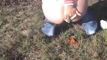 Young woman removed her jeans and defecated on the grassy field