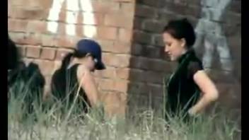 Dark-haired woman wearing a blue baseball cap defecates